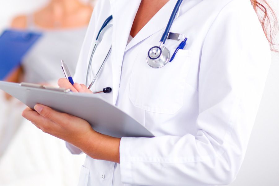 Eine Frau mit einem Klemmbrett in der Hand hat einen Kittel an